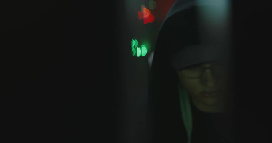 White teenager boy using a computer alone at a dark room