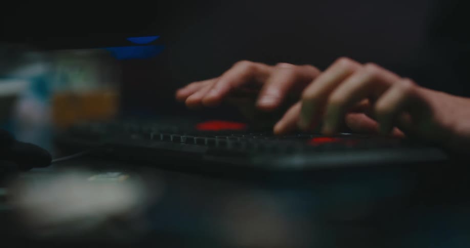 A person sitting at a desk typing on a keyboard