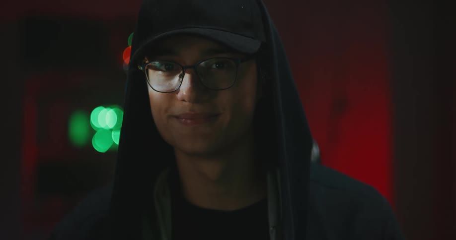 A person turning and staring at a camera while smiling