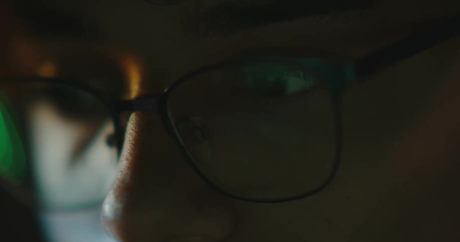 Close up of mans face with glasses at night