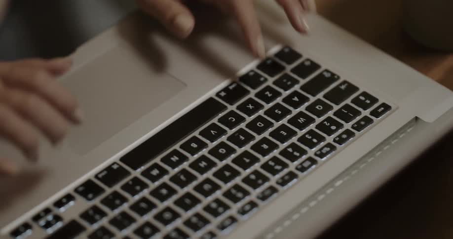Person wearing ring on their right hand is using a couple of fingers to type on a laptop keyboard
