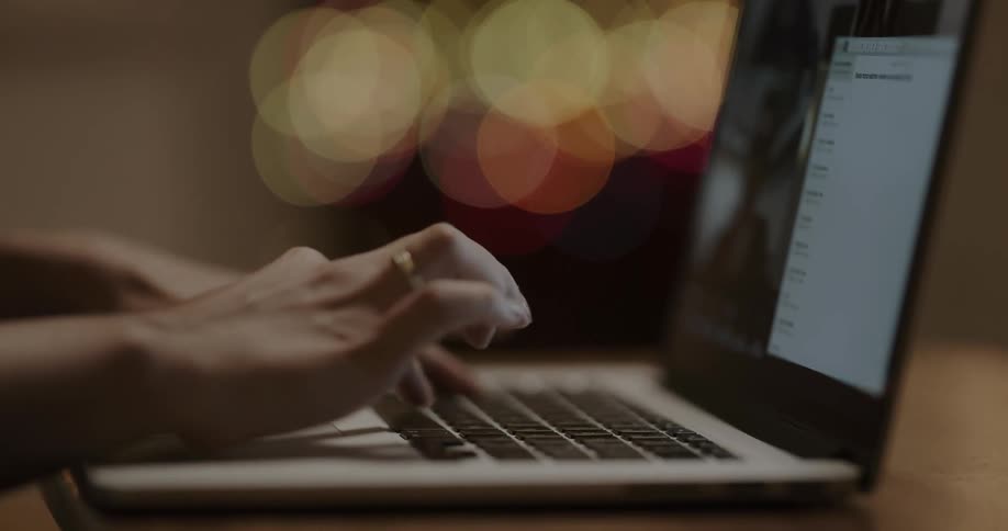 A womans hands as she types on a laptop