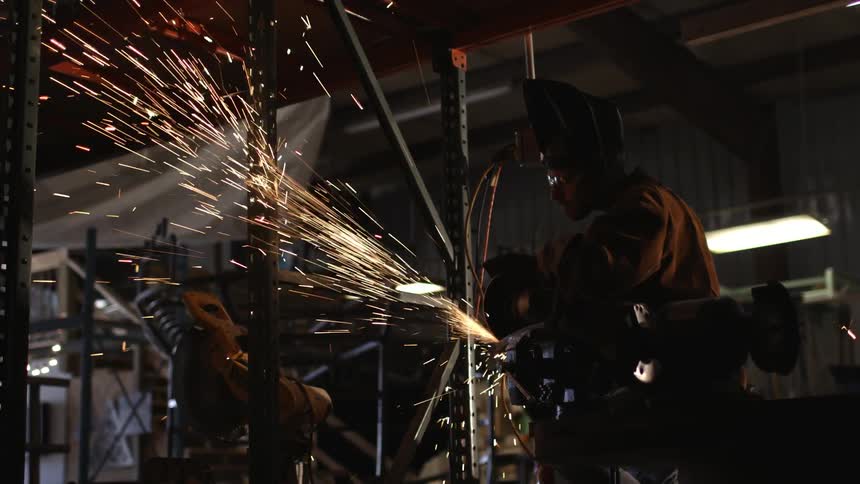 A man sawing metal in a workshop