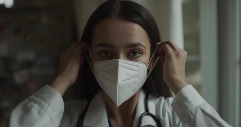 A doctor putting on a mask