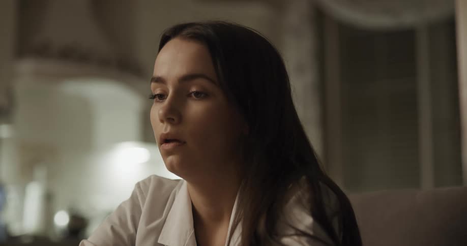 A doctor sitting down and taking off her mask and stethoscope