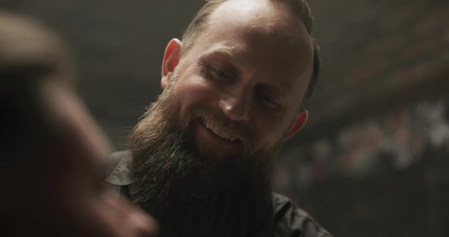 Barber styling the beard and mustache of his customer at a barber shop