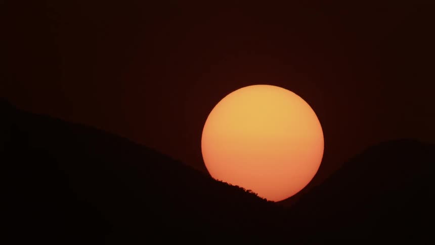 Sun setting between two mountains