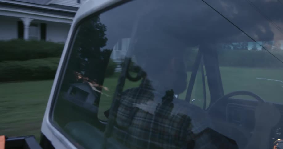 A man driving a truck in a neighborhood