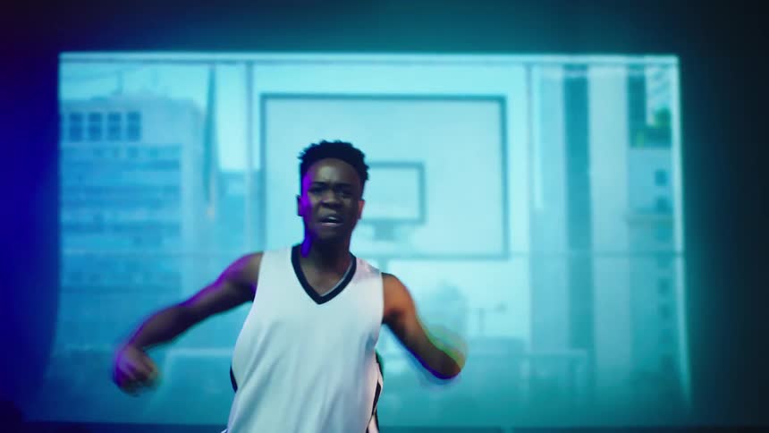 A boy on a stage dancing with images projecting in the background