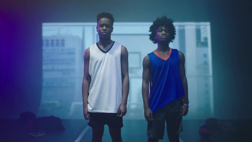 Two boys standing on a stage with images projected in the background