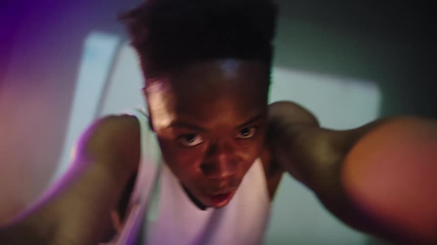 Dancer holding shaking the camera and performing in front of a big screen