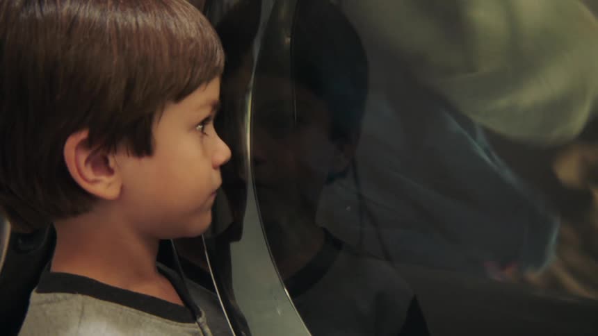 A child entranced by a washing machine
