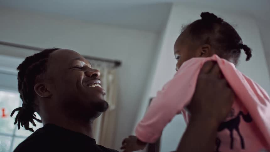 A father picking up his daughter and playing with her