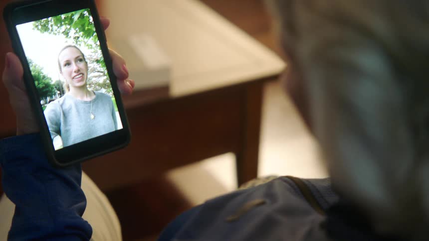 Elderly woman makes a video call with young woman on smartphone