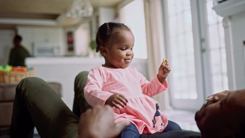A man and child sit near the fireplace playing
