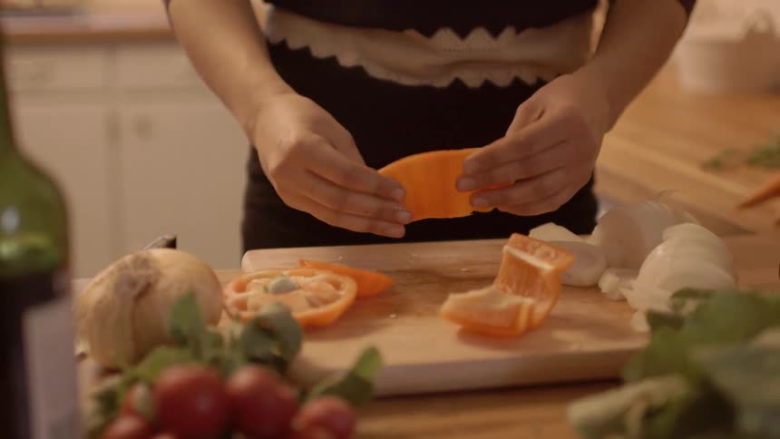 A woman cleaning and cutting peppers