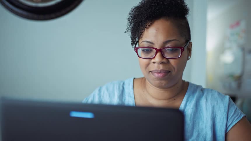 Woman inside her house on a video call on her laptop