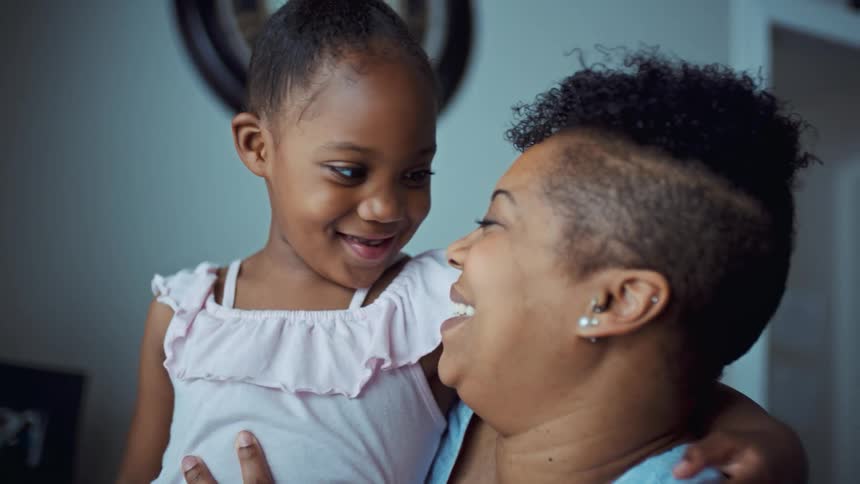 A mother and daughter kissing