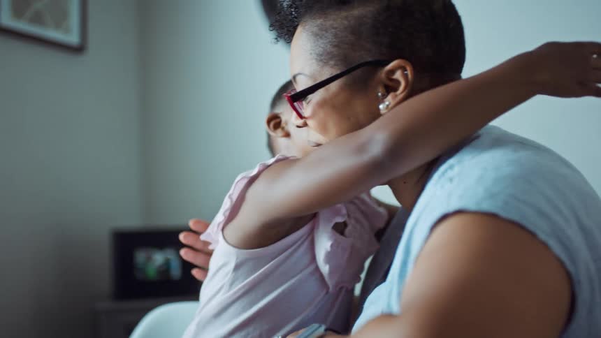 A woman puts up her hand for her daughter to high fiver her but her daughter hugs her instead