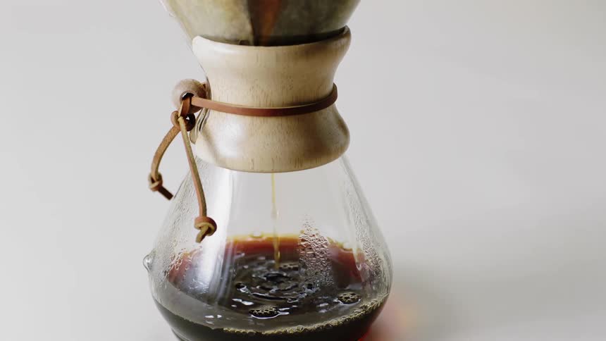 Hot water is poured into a filter and coffee drips down into a glass carafe