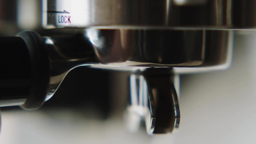 A barista locks a portafilter on an espresso machine