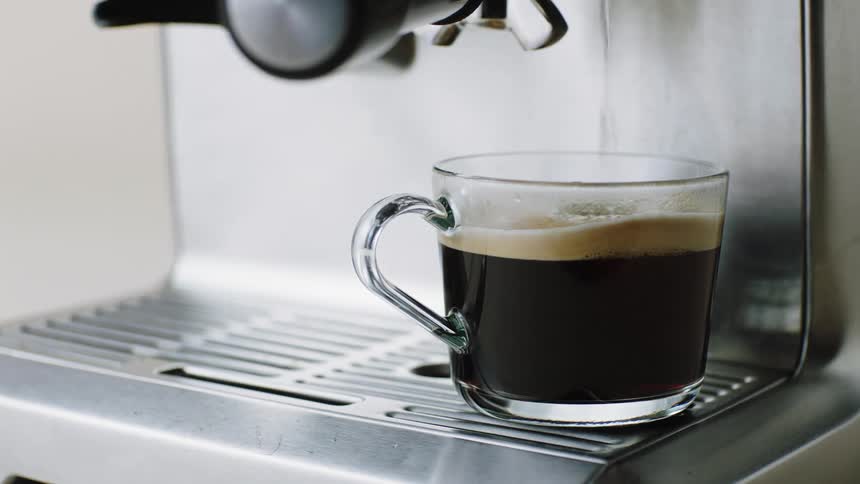Coffee filling a cup from an espresso machine