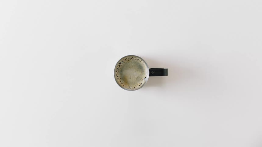 A mug of coffee is on the white counter