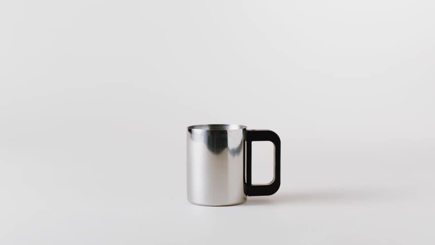 A metal mug with a black handle is displayed against a white backdrop