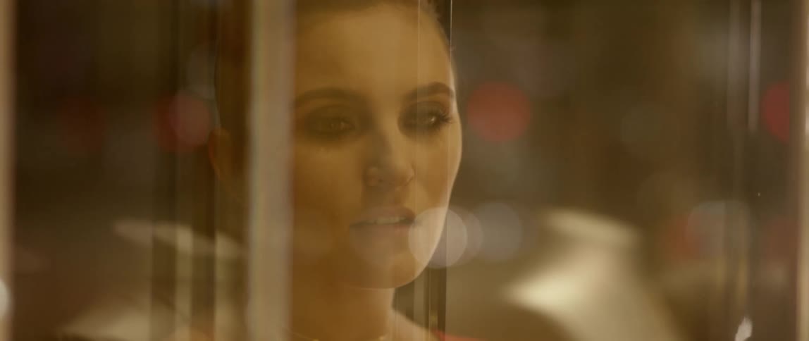 A woman looking out a window at lights