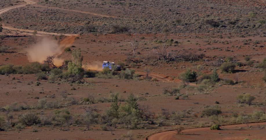 A car races on the trail over the hills