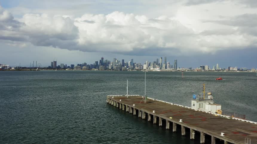 A long boat harbor sits across the ocean from downtown