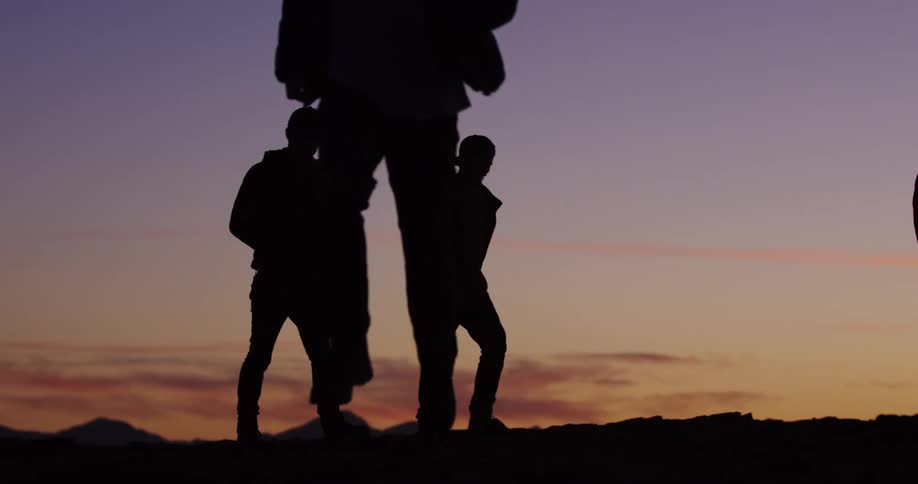A man runs in the opposite direction of friends as they hike on the top of a canyon