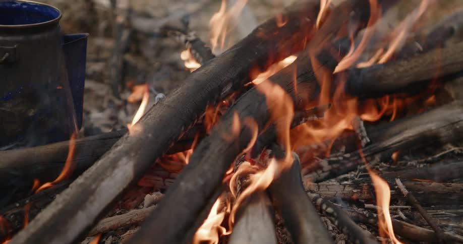 Campfire burning with branches on fire and flames flickering