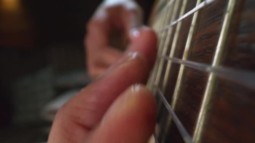 A man sits at home and plays the guitar