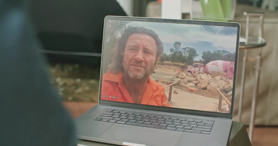 A person sitting at a desk video chatting on a laptop
