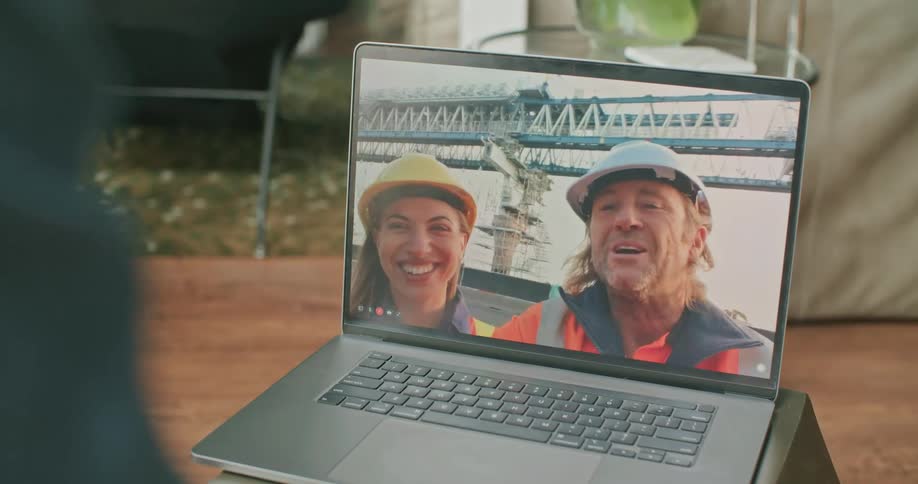 Man video calling construction workers on his laptop