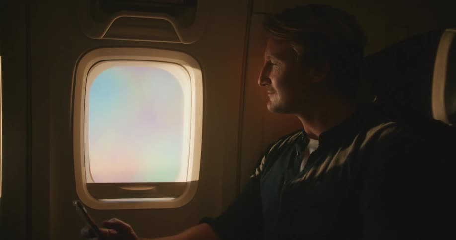 A man sitting in a plane with a phone