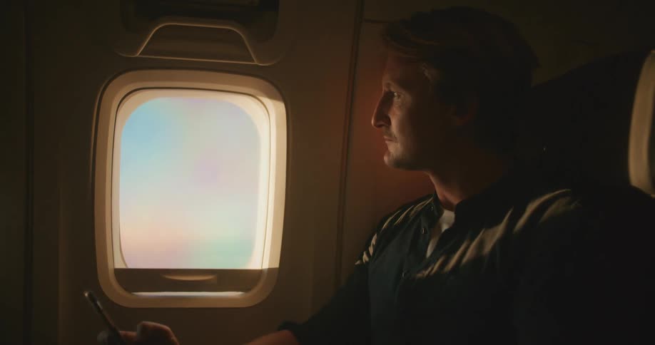 A man sitting in a plane with a phone