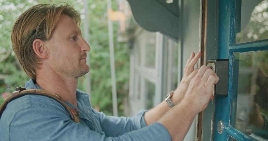 A man opens the door and enters the house