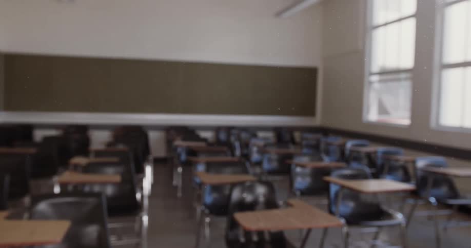 Sunlight pours through the windows into an empty classroom