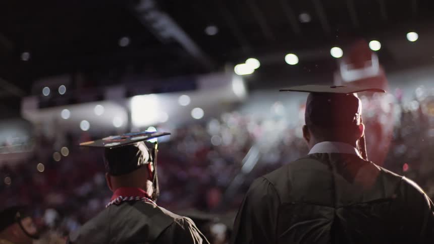 Graduates marching through an auditorium