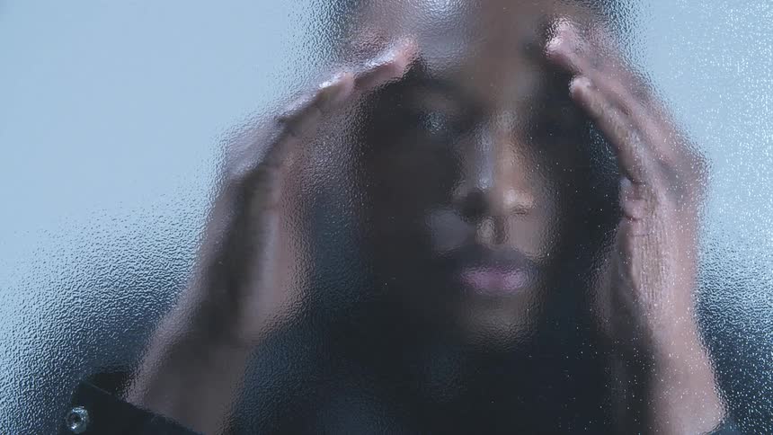 A man looking through an opaque glass