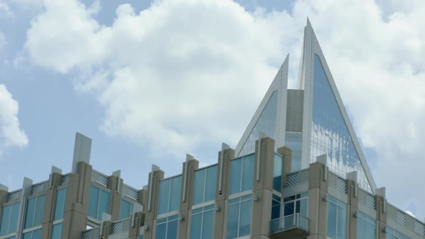 A large glass building beneath a cloudy sky in the daytime