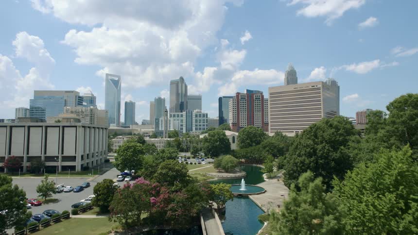 A river winds through a park that leads to downtown
