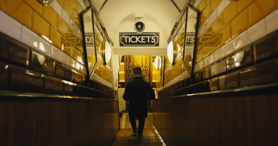 A man climbs down the staircase by the ticket booth