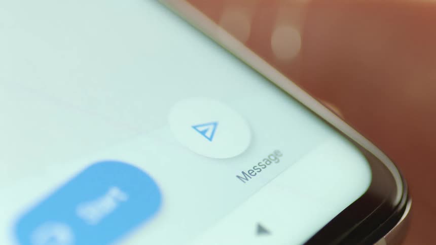 Cinematic macro shot of a finger tapping the blue send button on a smartphone screen as a messaging app interface appears. Perfect for illustrating texting, social interaction, UX/UI transitions, and digital communication in modern apps.