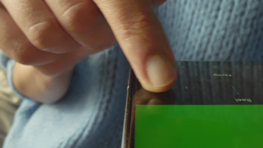 Stylized macro shot using a probe lens showing a finger moving a vertical slider on a smartphone screen. Minimal, tactile motion captured in natural light — ideal for app design, UX motion studies, digital technology, and interface control visuals.