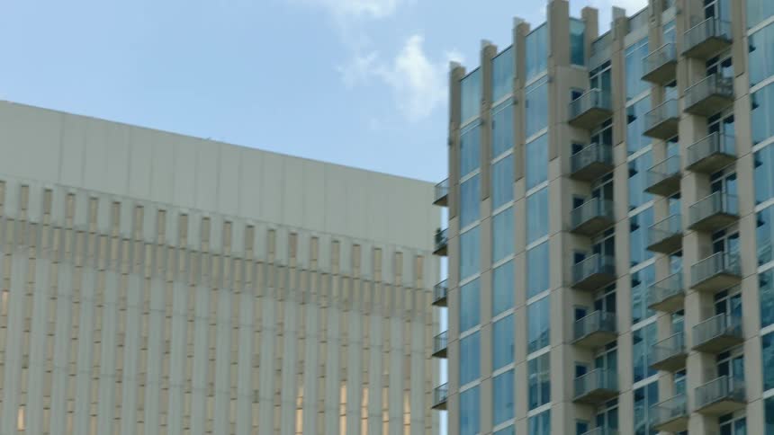 Windows of skyscrapers in city tower block reflect cloudy sky