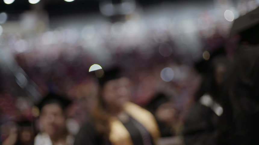A blurry view of graduates walking in line