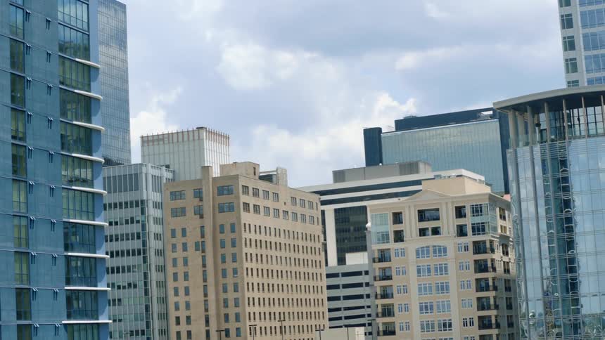 A gap between skyscrapers in the a metropolis reveals a cloudy daytime sky
